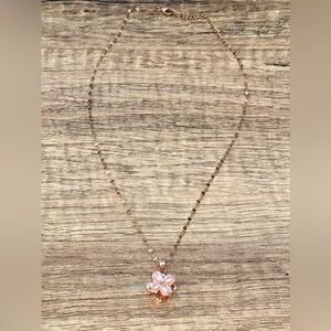 Rose gold stainless steel necklace with spinning clover pendant.